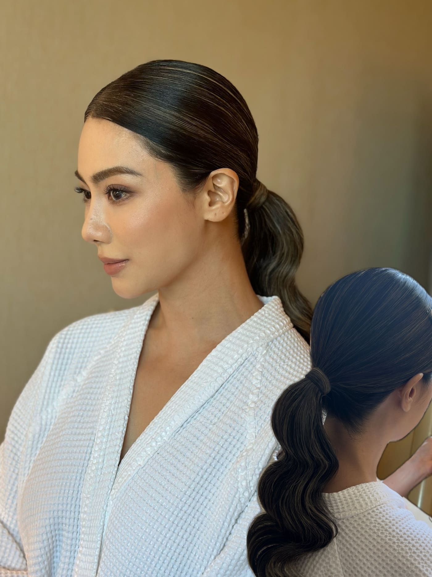 Sleek low ponytail with soft waves, seen from the side
